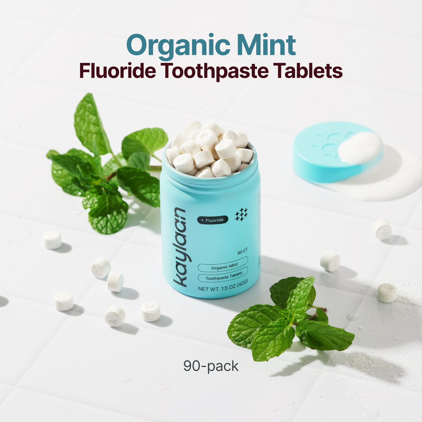 Kaylaan Organic Mint Fluoride Toothpaste Tablets 90-count in teal reusable container with fresh mint leaves
