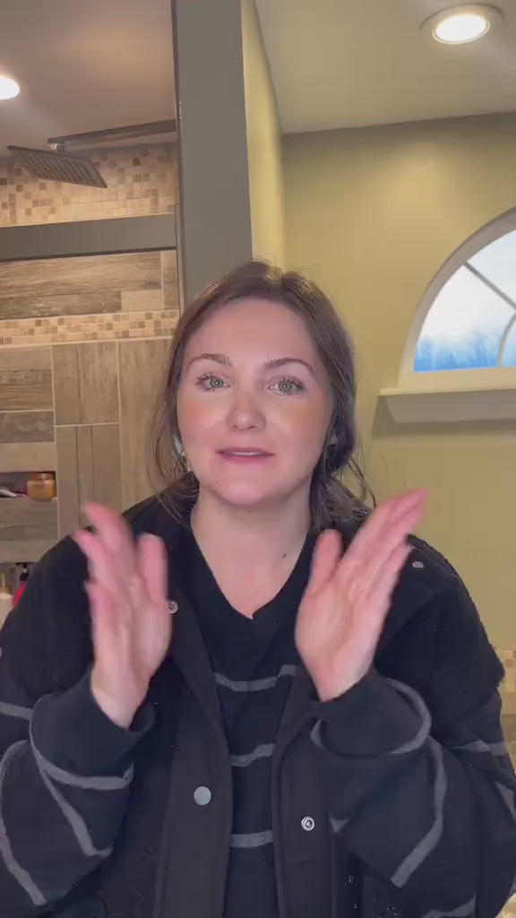 A smiling woman clapping her hands and talking directly to the camera while sharing a plastic-free oral care review for Kaylaan.
