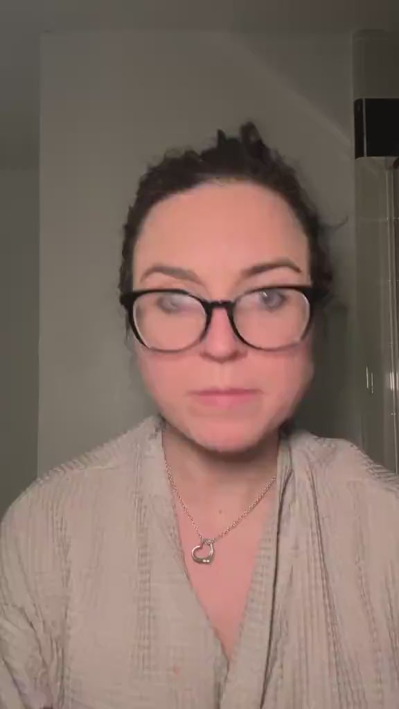 A woman wearing glasses sharing her review and experience switching to zero-waste Kaylaan toothpaste tablets.